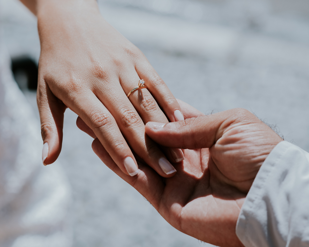 Man holding woman's hand showing engagment ring