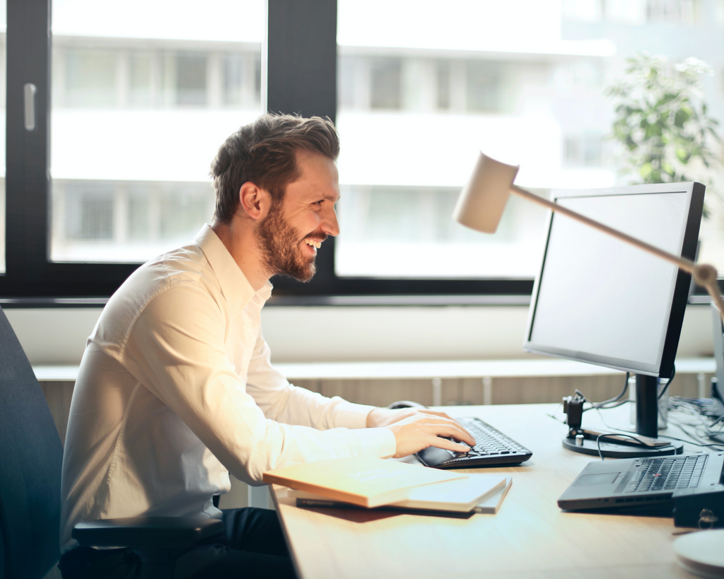 man-sitting-at-computer-scheduling-virtual-appointment-online