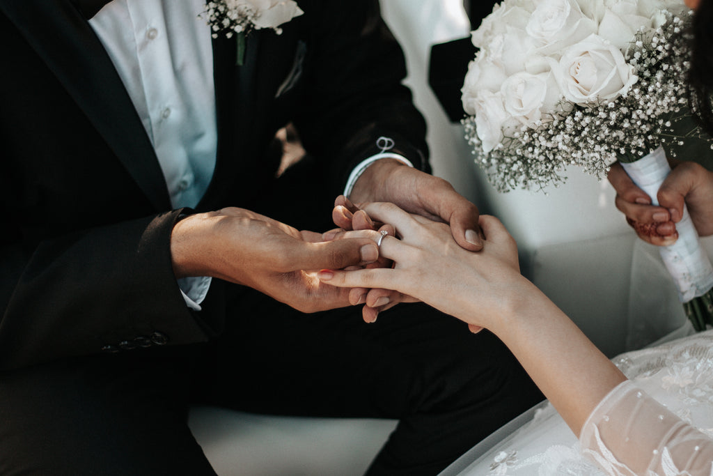 husband-placing-ring-on-wifes-hand-on-wedding-day